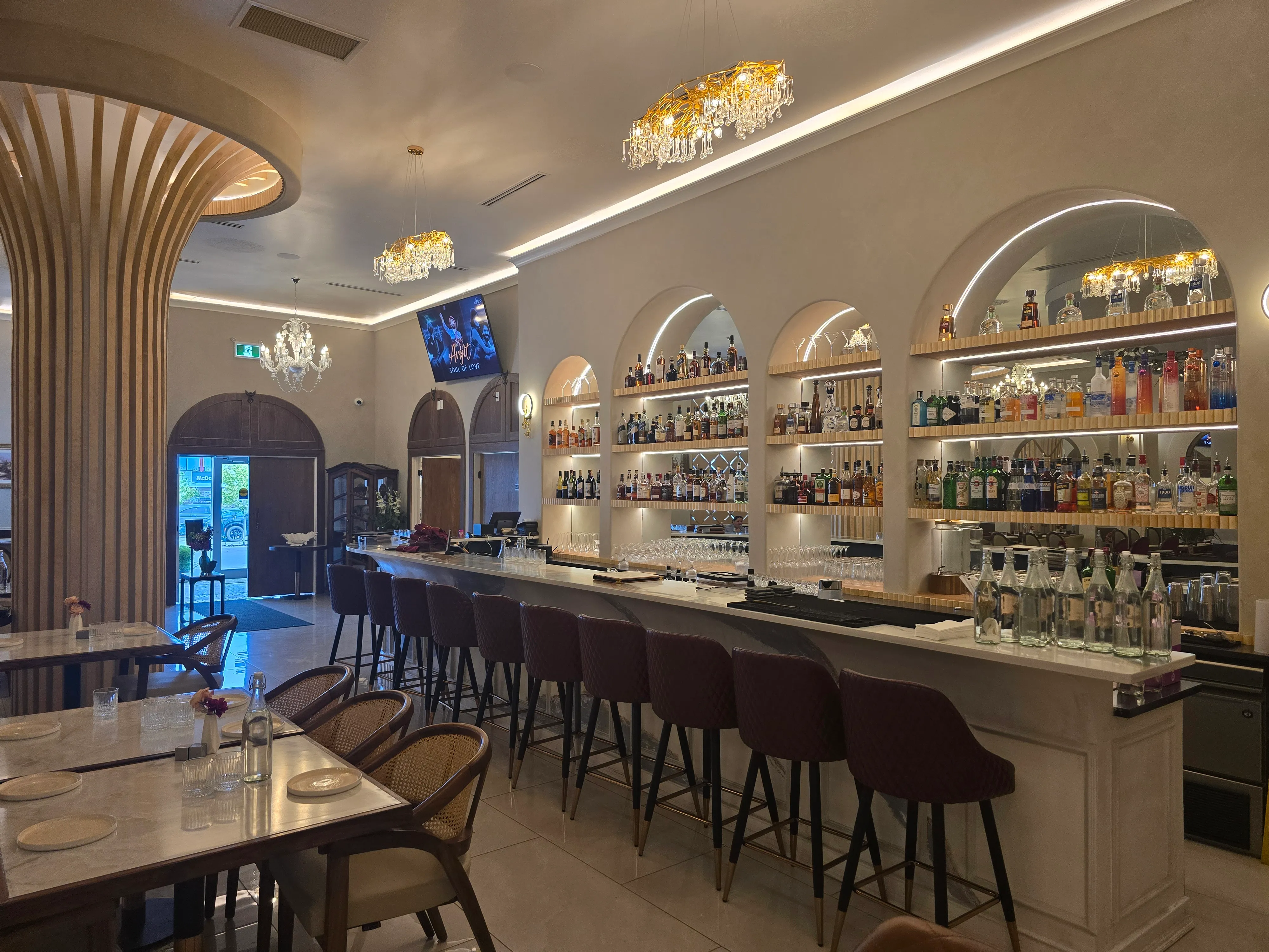 Ghazal Fine-Dine bar and lounge in Tamarack, Edmonton — marble counter, leather bar stools and backlit liquor shelves
